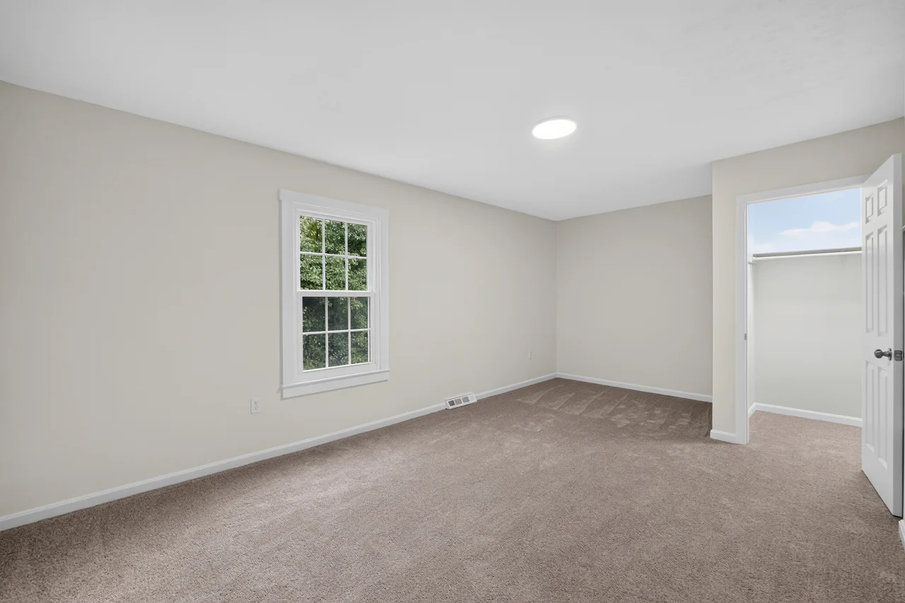 Carpeted bedroom with closet